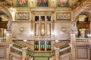 Grand ornate staircase inside a historic opera house.