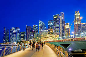 City skyline and people walking at sunset near Marina Bay