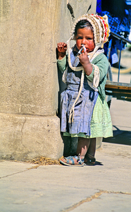 Young child in traditional attire appears to be smoking.