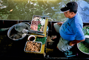 Food seller prepares dishes at Bangkok floating market
