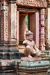Ancient Khmer temple with detailed carvings and a stone guardian