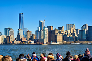 Tourists view Manhattan skyline from a boat on the water in New 