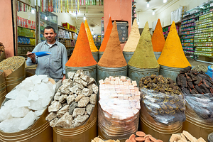 Spice seller in souk of Marrakesh shows colorful spices in Moroc
