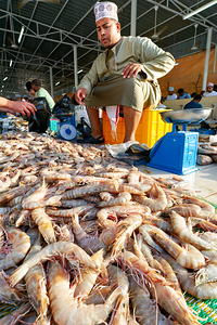 Fish market in Muscat Oman shows vendor and fresh catch
