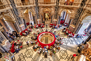 People dining in a grand ornate historic cafe interior.