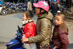 Children riding a motorbike in Hanoi streets