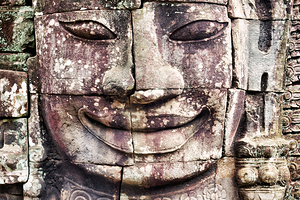 Ancient stone face carving with serene expression.