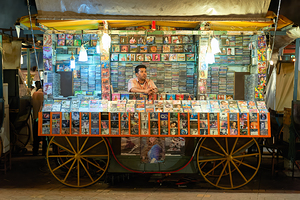 CD stall in Marrakesh at night with vendor selling music by Marco Brivio