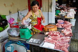 Local butcher weighs meat in Ho Chi Minh City market