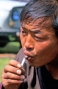 Tsaatan man smokes near his home in Mongolia by Marco Brivio