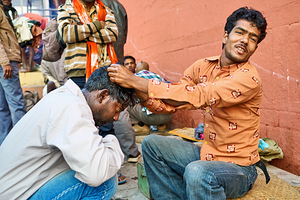 Barber cuts hair at shop in Varanasi Uttar Pradesh India