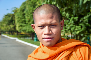 Portrait of a young Buddhist monk in orange robe.