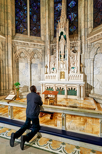 Man prays at St. Patricks Cathedral chapel in New York City