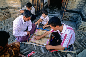 Men playing a board game in daylight in Khiva