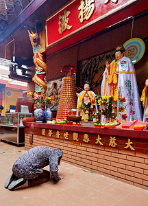 Person praying at a temple in Ho Chi Minh City Vietnam by Marco Brivio