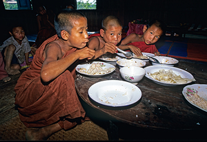 Monks have lunch in Mandalay during the day in Myanmar by Marco Brivio