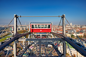 Ferris wheel cabin overlooking Vienna city skyline.