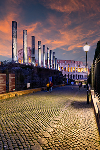 View of the Colosseum from Via Sacra in Rome during sunset