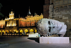 Sculpture of a large head in Krakow at night