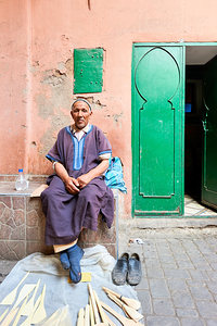 Portrait of old man sitting in Marrakesh Medina street by Marco Brivio