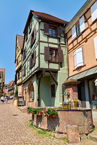 Visitors explore timber framed houses in Riquewihr on a sunny da