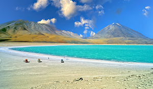 Turquoise lake mountains and travelers under a blue sky. by Marco Brivio