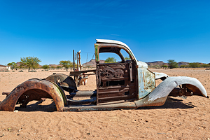 Classic car wreck rests in the Namib desert under a clear sky