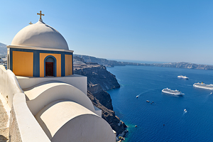 Santorinis iconic church and caldera with ships.