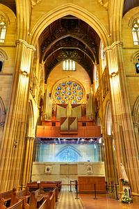 Interior of a grand cathedral with pipe organ and stained glass.