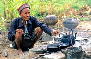 Man prepares tea in Myanmar under a clear sky by Marco Brivio