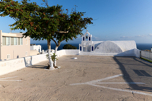 White church green tree and blue sea in Greece.