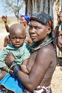 Portrait of young Zemba woman holding child in Kunene Region