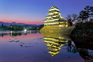 Matsumoto Castle stands by the water during sunset in Japan