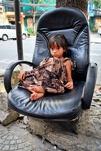 Child sitting in chair on street in Ho Chi Minh City