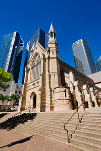 Historic church stands tall against modern skyscrapers.