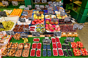 Colorful market stall overflowing with fresh fruits and nuts.