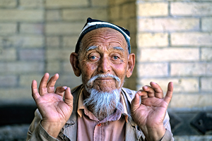 Elderly man showing hand gestures in Khiva Uzbekistan