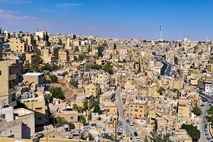 Cityscape of Amman Jordan with buildings and roads under blue sk