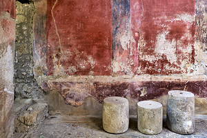 Pompeii site with stone seats and worn wall in Naples Italy