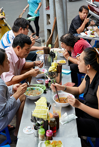 People eating at street food stalls in Ho Chi Minh City