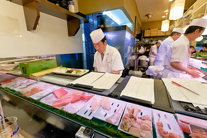 Sushi chefs preparing fresh dishes in Shibuya district of Tokyo