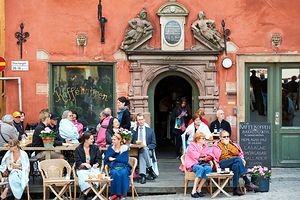 People resting in a cafe at Stortorget square in Gamla Stan by Marco Brivio