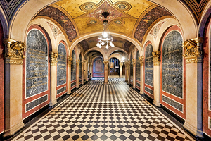 Historic church corridor with ornate arches and checkered floor.