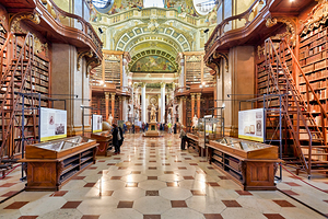 Ornate historic library interior with towering bookshelves and v