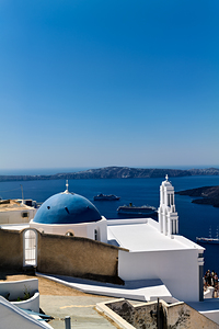 Santorinis blue domed church and bell tower overlooking the Aeg