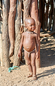 Child standing outside in a Himba village in Kunene Region Namib