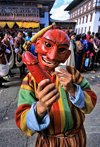 Masked figure holding phallus at a Bhutanese festival.