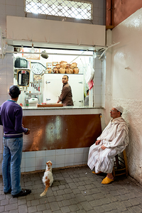 Busy shop in Marrakesh souk with local vendors and customers