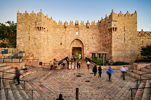 Damascus Gate in Jerusalem during sunset with people walking