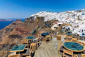 Santorini cafe terrace overlooking caldera and white village.